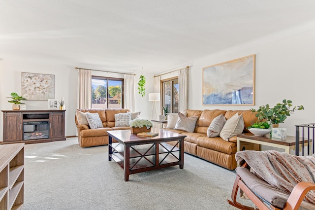 living room with a glass covered fireplace and light colored carpet