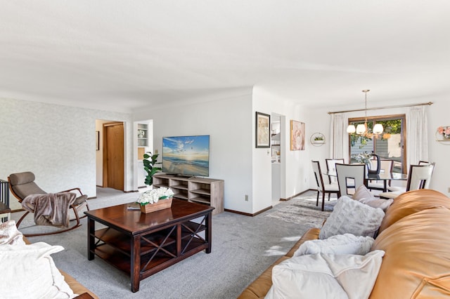 carpeted living room featuring baseboards and a notable chandelier