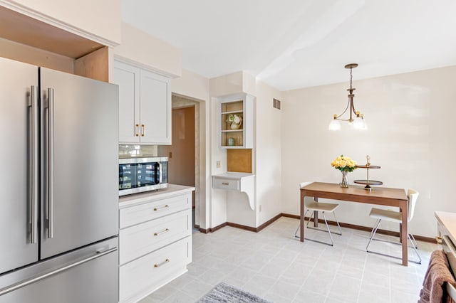 kitchen with stainless steel appliances, baseboards, white cabinets, light countertops, and an inviting chandelier