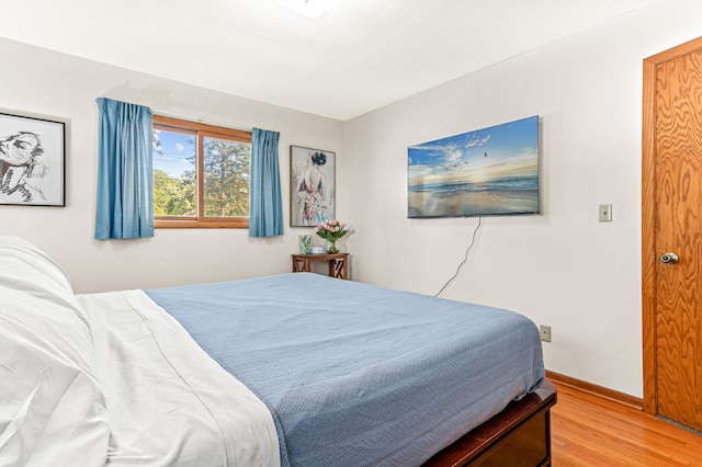 bedroom featuring baseboards and wood finished floors