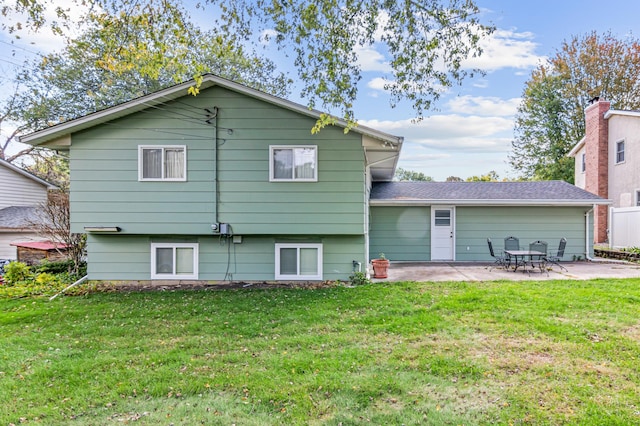 rear view of house featuring a lawn and a patio