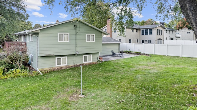 rear view of house featuring a yard, a patio area, and fence