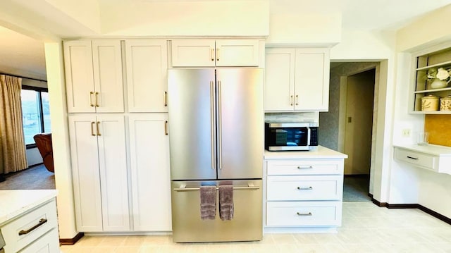 kitchen with baseboards, appliances with stainless steel finishes, light countertops, white cabinetry, and open shelves