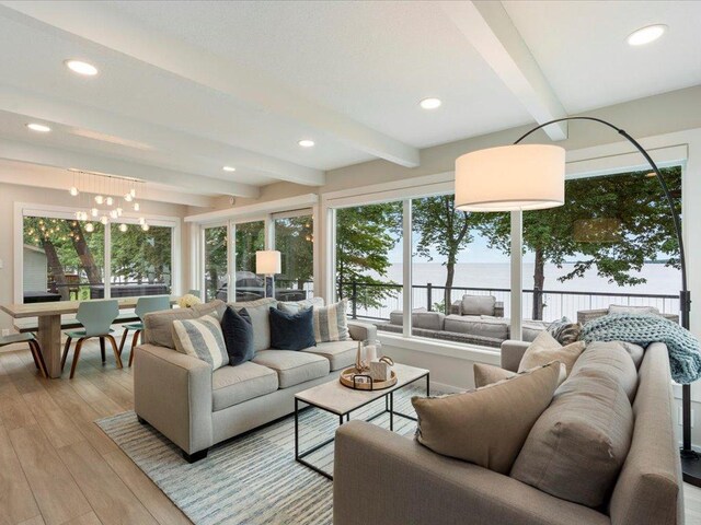 living room with recessed lighting, a notable chandelier, beam ceiling, and light wood-style floors
