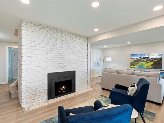 living area with a fireplace, recessed lighting, light wood-style floors, and baseboards