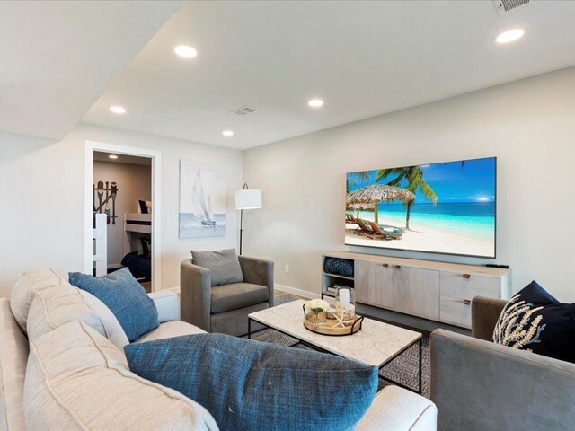 living area featuring recessed lighting, visible vents, and baseboards