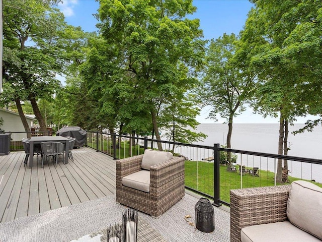 wooden terrace with outdoor dining area, a yard, and grilling area