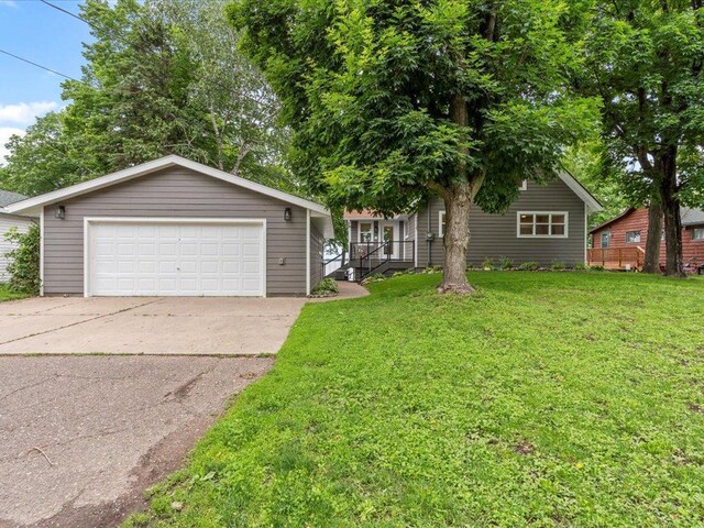 view of front of house featuring a front lawn and a detached garage