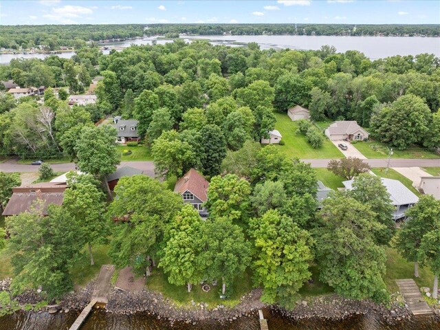 birds eye view of property featuring a forest view and a water view