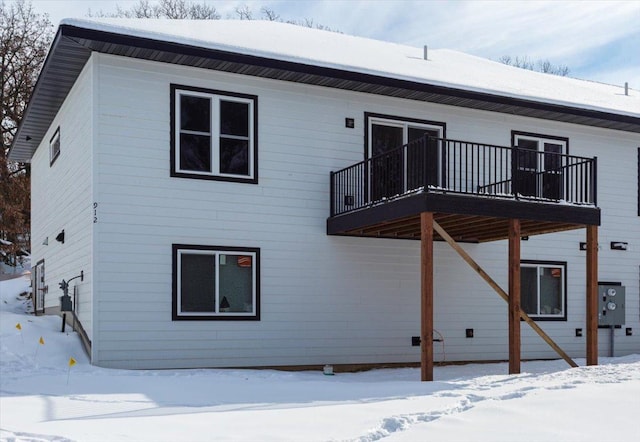 view of snow covered back of property