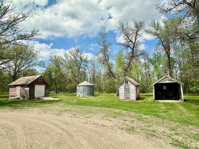 28714 County Road 112, Dieter Twp, MN 56751 - view of green lawn with a detached garage and view of wooded area