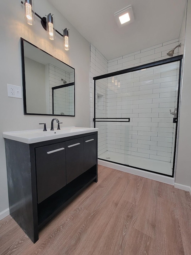 bathroom with a shower stall, vanity, and wood finished floors