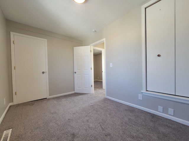 unfurnished bedroom with carpet, visible vents, and baseboards