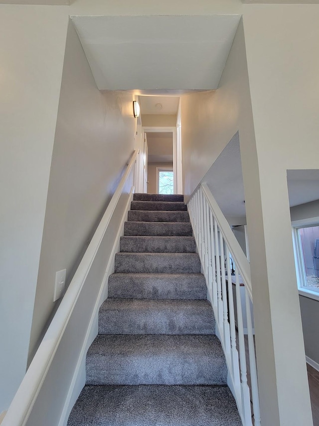 stairway with carpet floors and baseboards