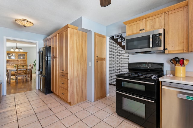 kitchen featuring black appliances, light tile patterned floors, light countertops, and light brown cabinetry