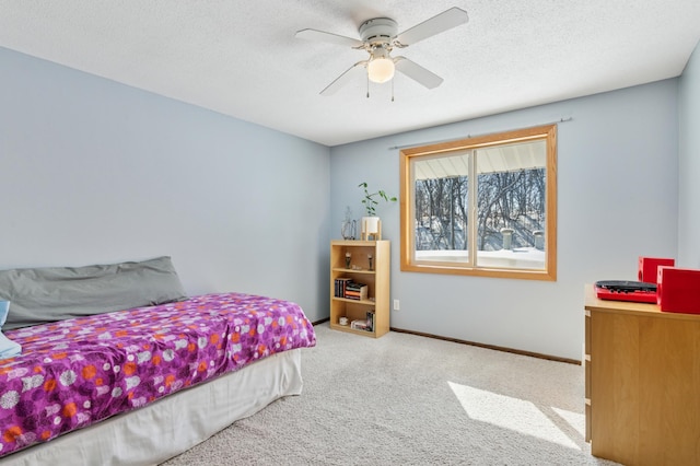 carpeted bedroom featuring baseboards, a textured ceiling, and ceiling fan