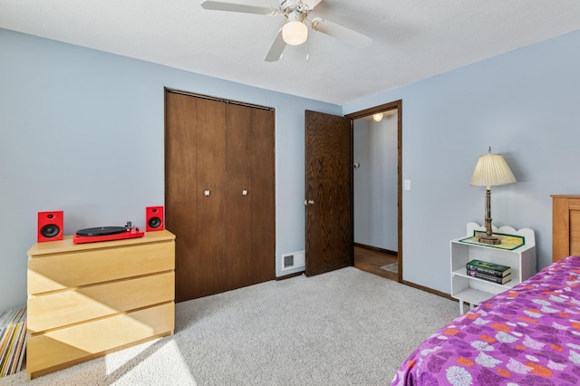 bedroom with visible vents, baseboards, carpet floors, a closet, and a ceiling fan