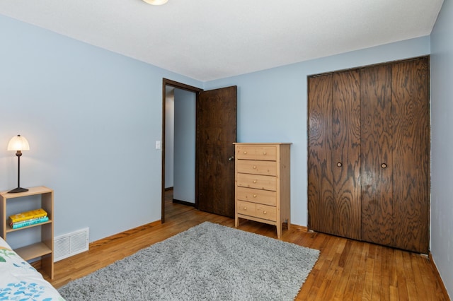 bedroom with visible vents and wood finished floors