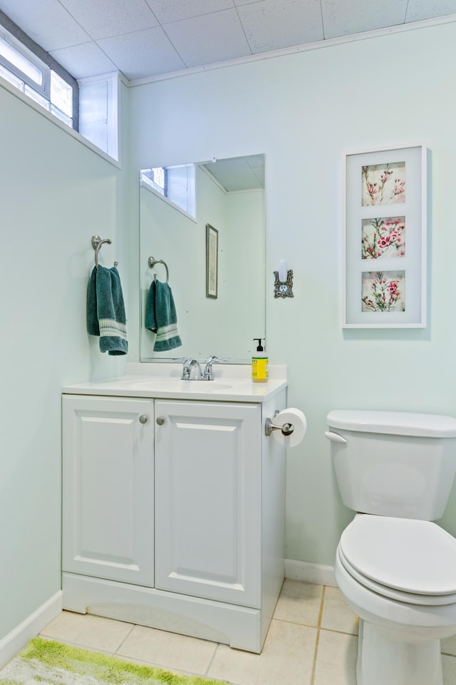 bathroom featuring tile patterned floors, baseboards, toilet, and vanity