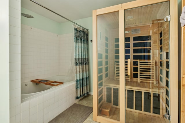 bathroom with tiled shower / bath combo and a sauna