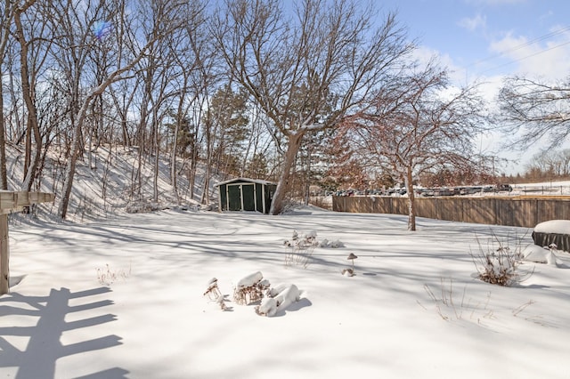 yard covered in snow featuring an outbuilding and fence