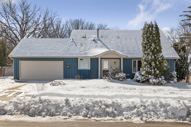 view of front facade featuring an attached garage, a shingled roof, and fence