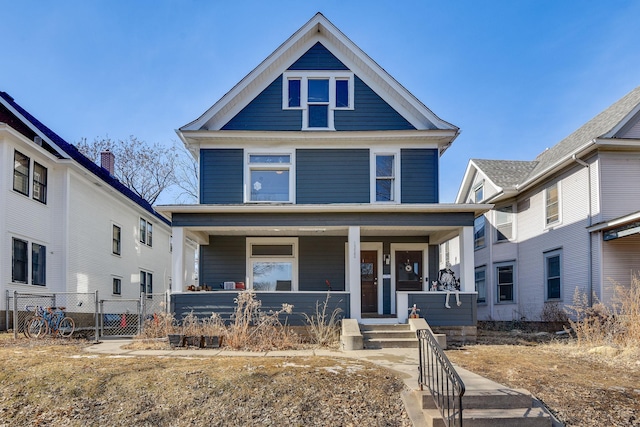 traditional style home with covered porch and fence