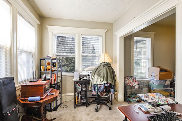 carpeted office space featuring a textured ceiling