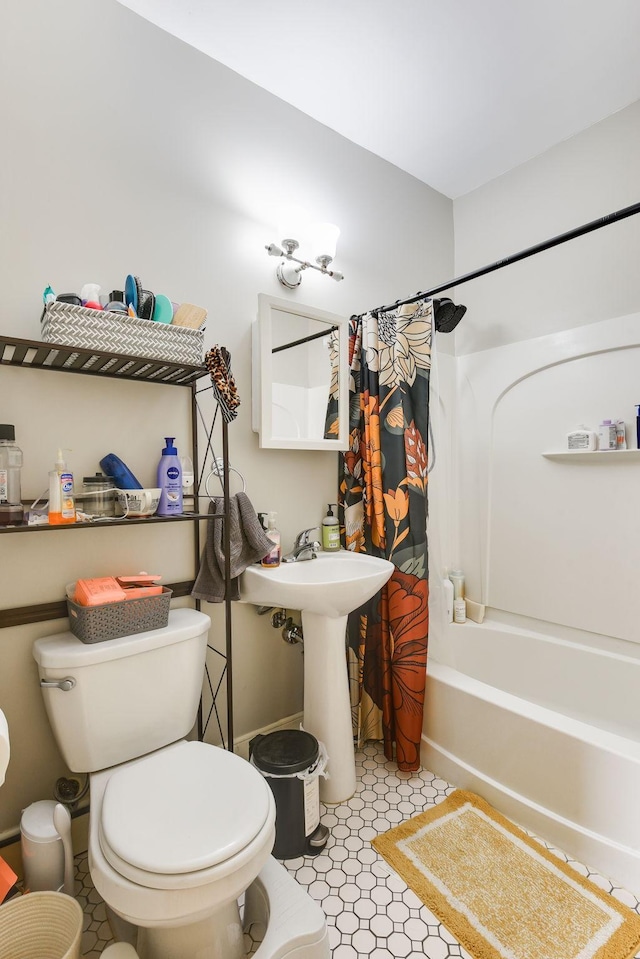 full bathroom featuring toilet, shower / bathtub combination with curtain, and a sink