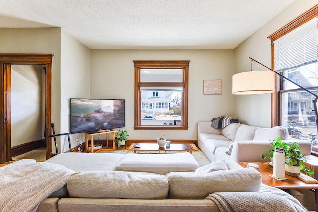 living room with a textured ceiling and baseboards