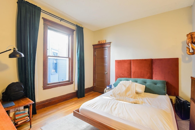 bedroom featuring light wood-type flooring and baseboards