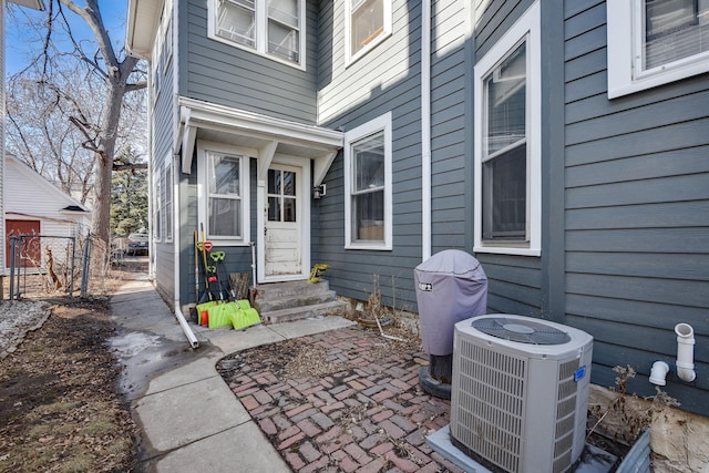 property entrance with central AC, a patio area, and fence