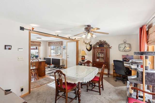 dining room with ceiling fan, baseboards, and light colored carpet