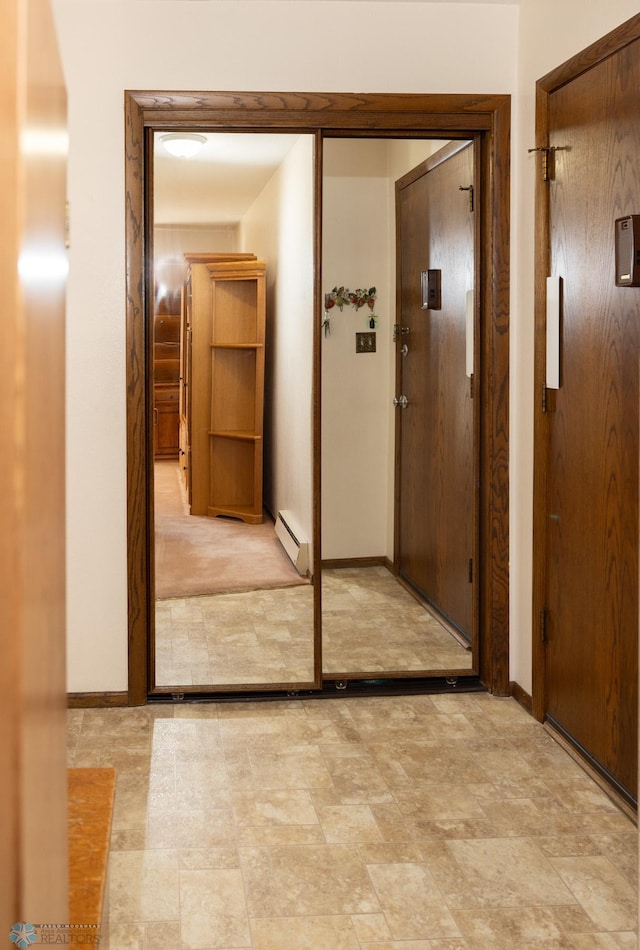 corridor with baseboards and baseboard heating