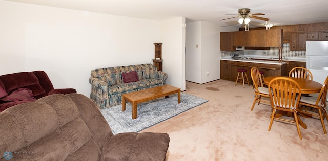 living area with light colored carpet and a ceiling fan