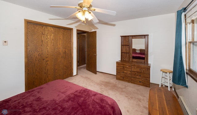 carpeted bedroom with ceiling fan, a closet, and a baseboard radiator