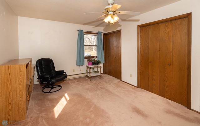 living area with carpet flooring, baseboard heating, and ceiling fan