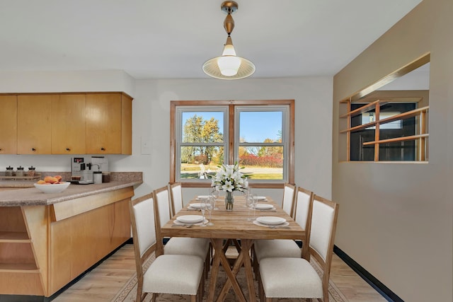 dining area featuring light wood-style floors and baseboards