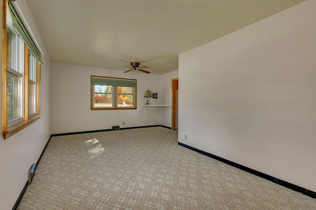 spare room with a ceiling fan, baseboards, and carpet flooring