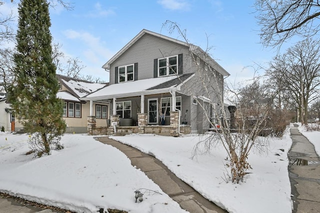 view of front of house featuring a garage, stone siding, and covered porch