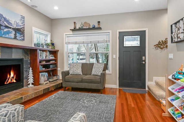 living area featuring recessed lighting, a tiled fireplace, wood finished floors, and baseboards