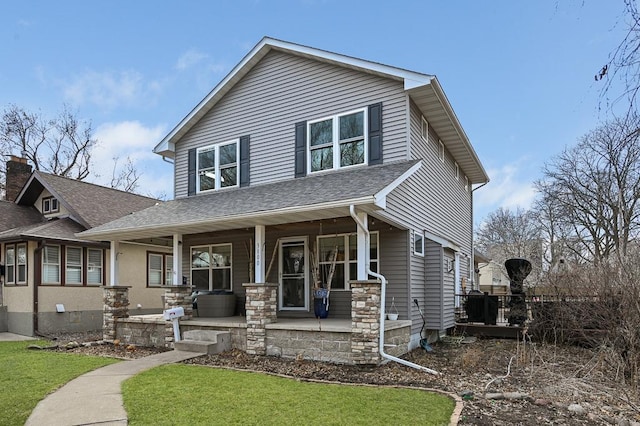 view of front of house featuring covered porch and a shingled roof