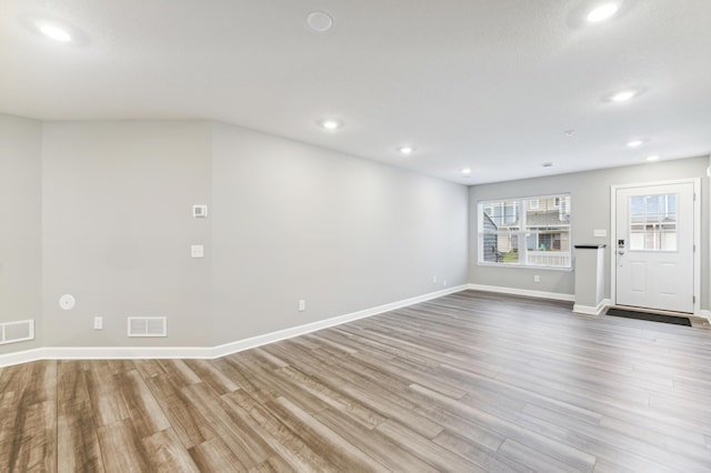 empty room with baseboards, visible vents, wood finished floors, and recessed lighting