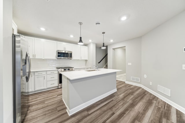 kitchen featuring stainless steel appliances, white cabinets, visible vents, and wood finished floors