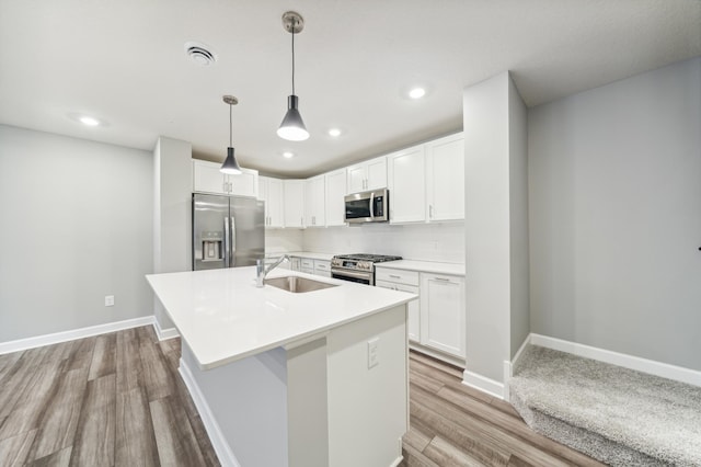 kitchen featuring stainless steel appliances, white cabinetry, a sink, and baseboards