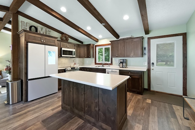 kitchen with light countertops, lofted ceiling with beams, appliances with stainless steel finishes, dark wood-type flooring, and dark brown cabinetry