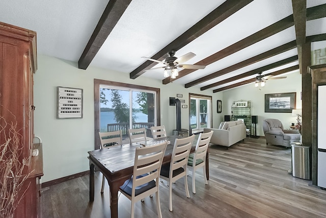 dining area with lofted ceiling with beams, baseboards, and wood finished floors