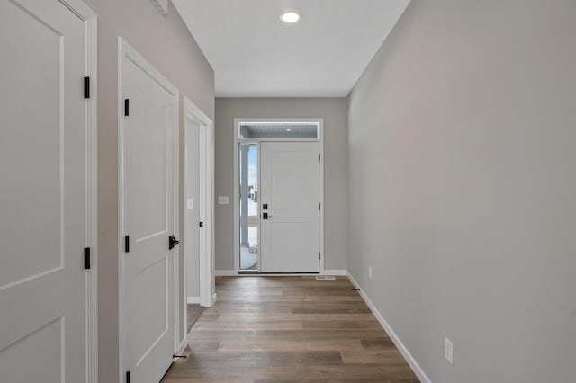 foyer with baseboards and wood finished floors