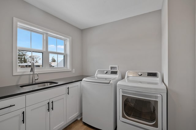 laundry area with washer and dryer, cabinet space, and a sink