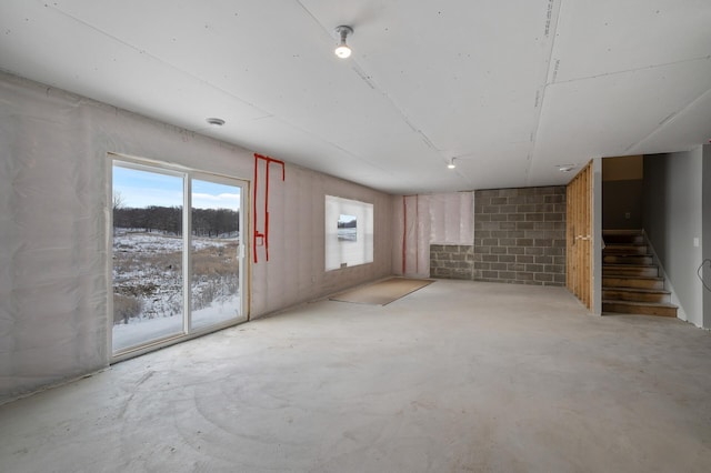 unfurnished room with stairs and concrete flooring